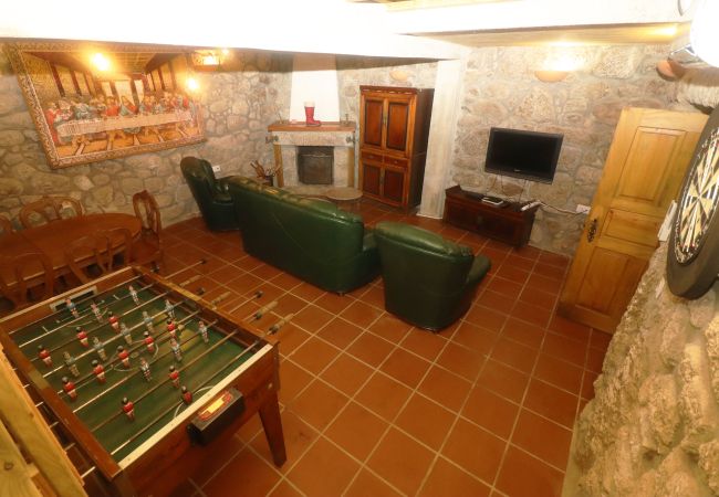 Sala de estar com lareira e jogos em alojamento na natureza Sala Lareira Jogos Natureza Geres